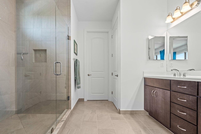 bathroom with tile patterned floors, a shower stall, baseboards, and vanity