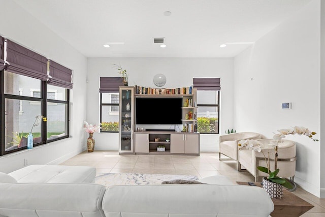 living area featuring baseboards, light tile patterned flooring, visible vents, and recessed lighting