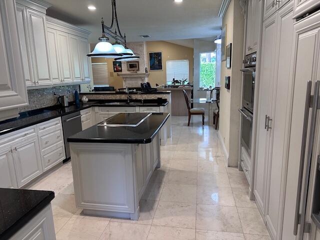 3271 Harrington Dr, Boca Raton, FL 33496 - kitchen with black electric cooktop, stainless steel dishwasher, dark countertops, a sink, and double oven
