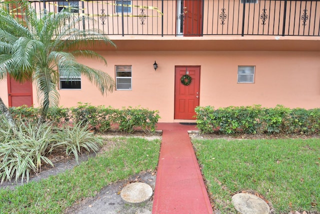 doorway to property with a balcony and stucco siding