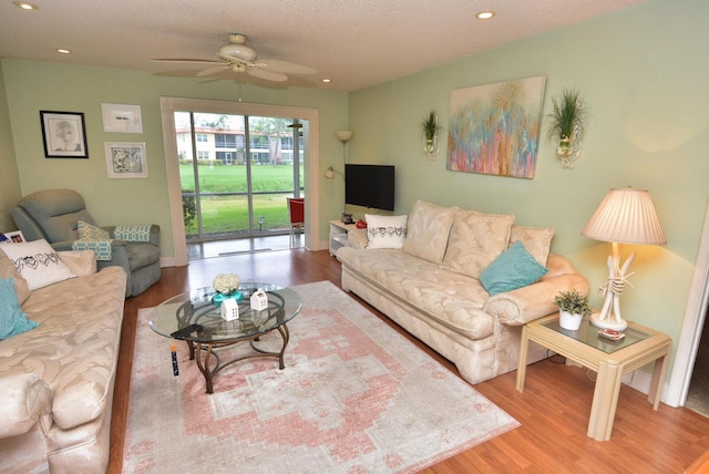 living area featuring a textured ceiling, wood finished floors, and recessed lighting