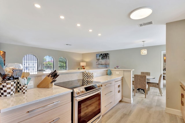 kitchen featuring light stone counters, visible vents, light wood-style floors, stainless steel range with electric cooktop, and modern cabinets