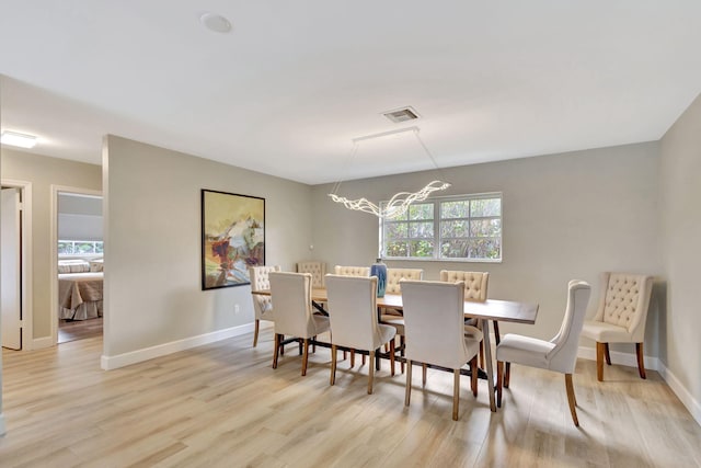 dining area featuring baseboards, visible vents, and light wood-style floors