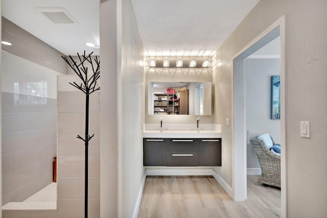 full bathroom featuring baseboards, visible vents, wood finished floors, and vanity