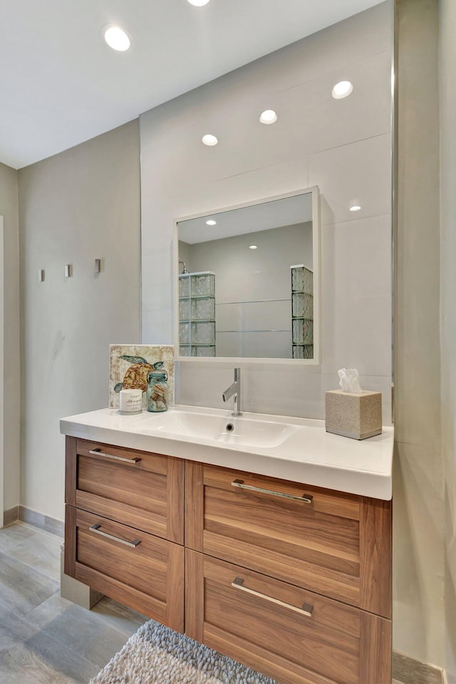 full bath featuring recessed lighting, vanity, baseboards, and walk in shower