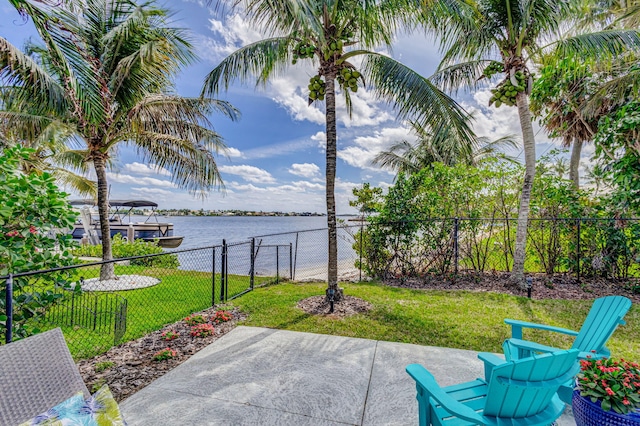 view of patio featuring a water view and fence