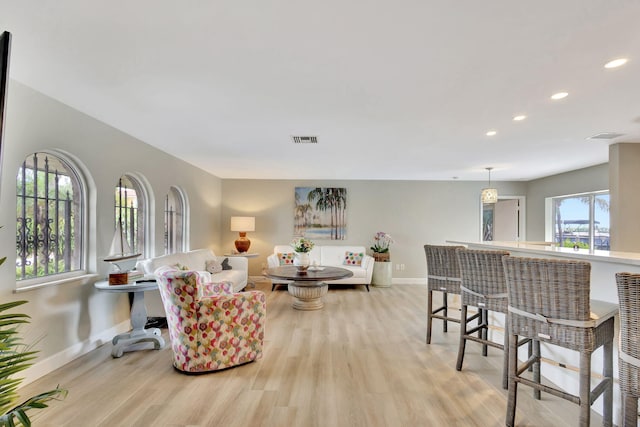 living room featuring light wood-style flooring, recessed lighting, visible vents, and baseboards