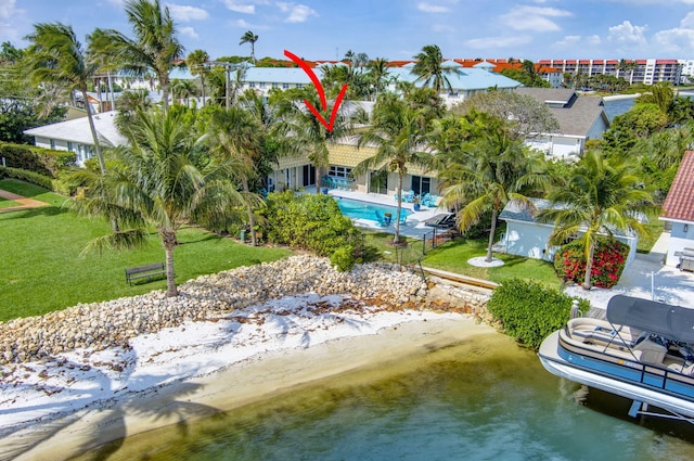 exterior space featuring a lawn, a water view, and an outdoor pool