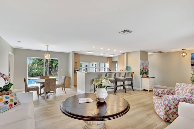 living room with recessed lighting, visible vents, light wood-style flooring, and baseboards