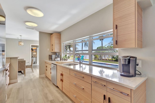 kitchen featuring stainless steel appliances, visible vents, light brown cabinets, a sink, and light wood-type flooring