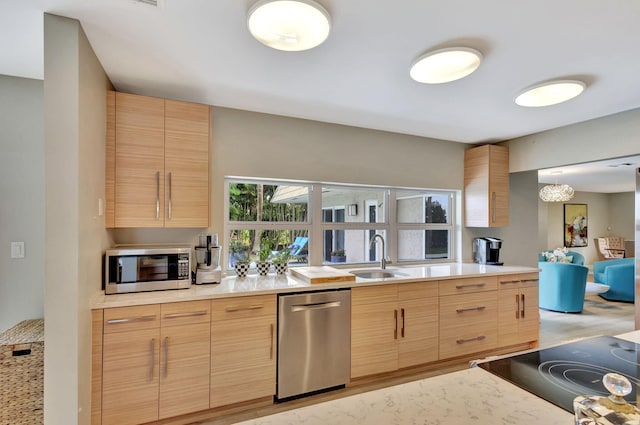 kitchen featuring appliances with stainless steel finishes, light countertops, light brown cabinets, and a sink