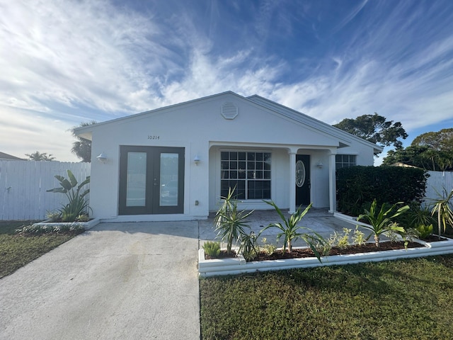 view of front of house featuring french doors, fence, and stucco siding