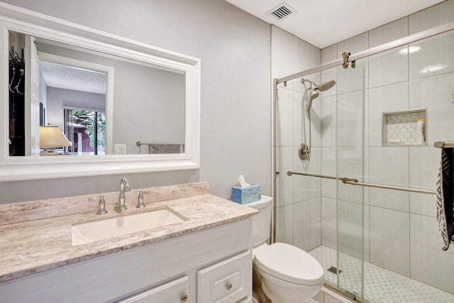 ensuite bathroom featuring visible vents, toilet, a stall shower, connected bathroom, and vanity