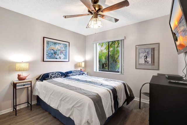 bedroom with dark wood-style floors, ceiling fan, a textured ceiling, and baseboards