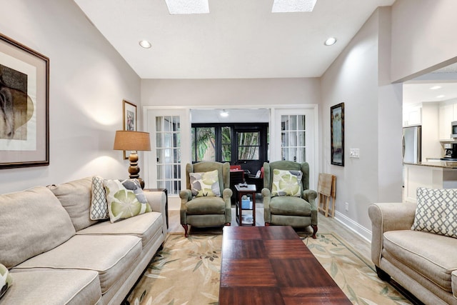 living room featuring light wood-type flooring, recessed lighting, a skylight, and baseboards