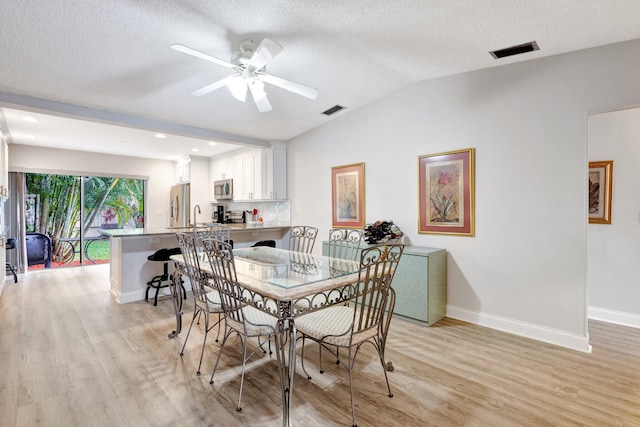 dining area featuring light wood finished floors, baseboards, and visible vents