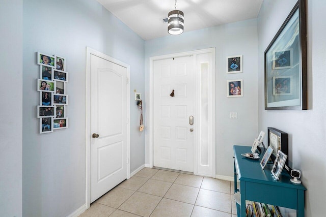 entrance foyer with light tile patterned flooring and baseboards