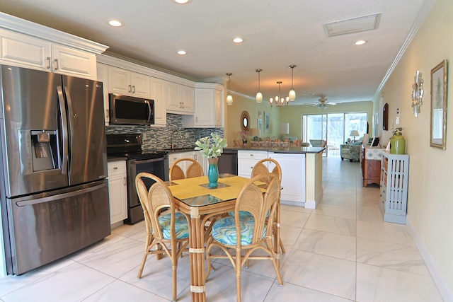 kitchen with black appliances, ornamental molding, dark countertops, and a peninsula