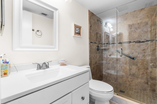 bathroom featuring toilet, a shower stall, visible vents, and vanity