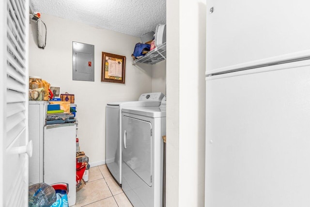 laundry room featuring light tile patterned floors, laundry area, electric panel, a textured ceiling, and washing machine and dryer