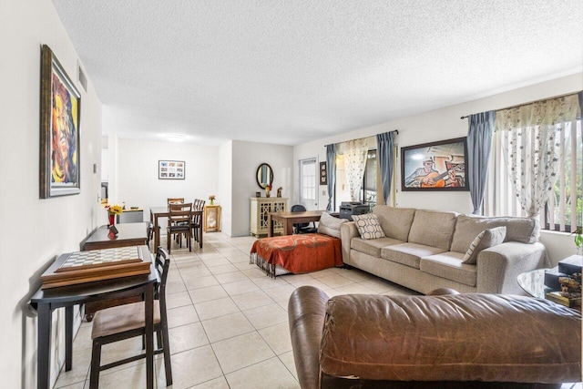 living room featuring visible vents, a textured ceiling, and light tile patterned floors