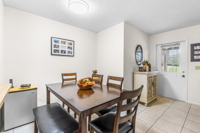 dining room featuring light tile patterned floors and a textured ceiling