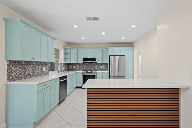 514 Jaeger Dr, Delray Beach, FL 33444 - kitchen featuring appliances with stainless steel finishes, a sink, backsplash, a peninsula, and light countertops