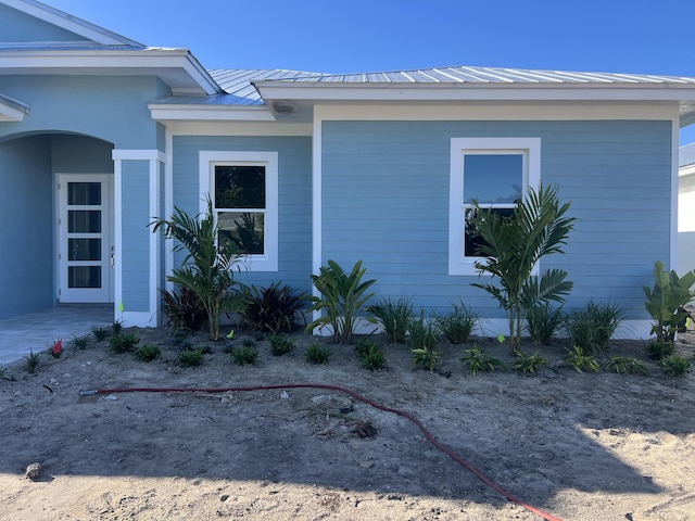 view of property exterior with a standing seam roof and metal roof