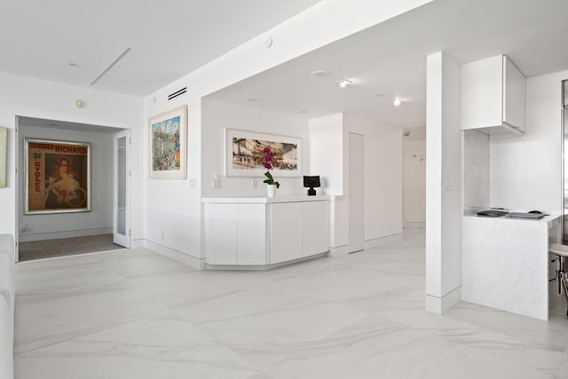 hallway featuring marble finish floor