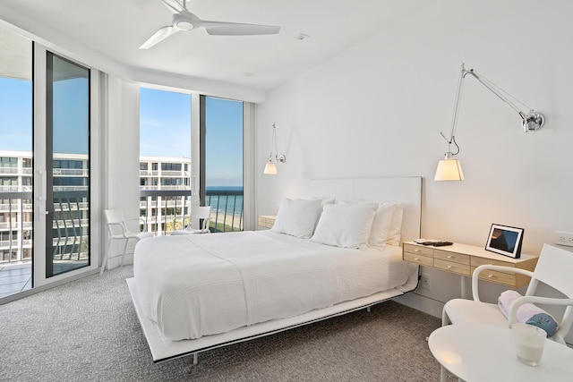 bedroom with access to exterior, ceiling fan, a wall of windows, and carpet flooring