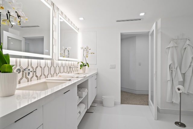 full bathroom with double vanity, a sink, and backsplash