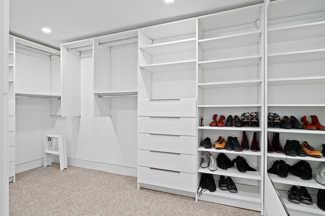 walk in closet with light colored carpet