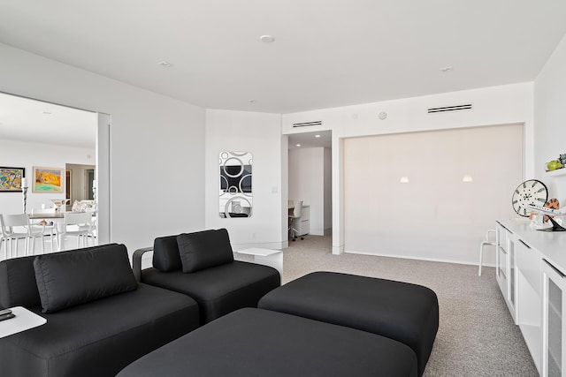 carpeted living area with visible vents and baseboards