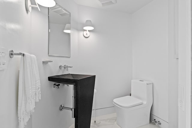 bathroom featuring marble finish floor and toilet