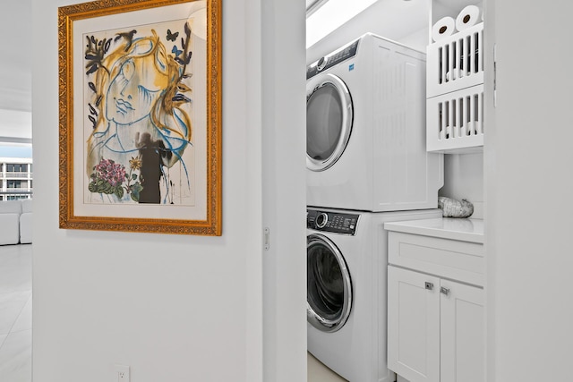 laundry area with cabinet space and stacked washer / dryer