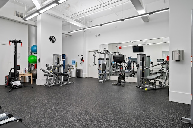 gym featuring a high ceiling and visible vents