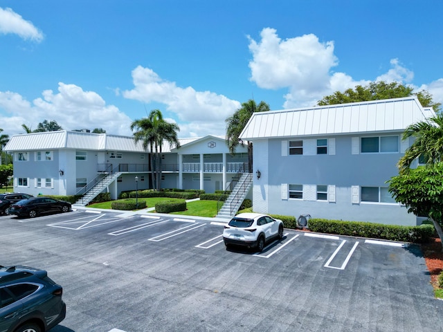 view of building exterior featuring stairs and uncovered parking
