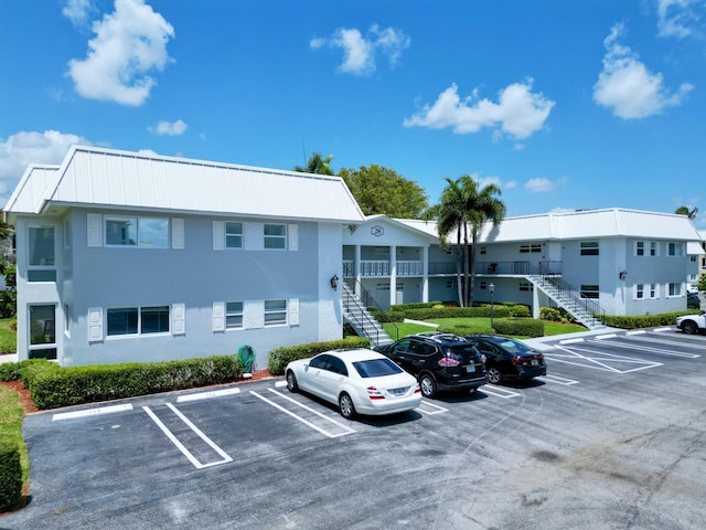view of building exterior featuring uncovered parking and stairway