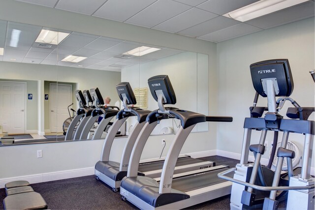 workout area with baseboards and a paneled ceiling