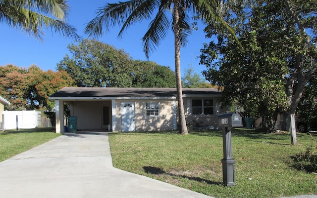 single story home featuring an attached carport, concrete driveway, fence, and a front lawn