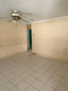 spare room featuring ceiling fan and ornamental molding