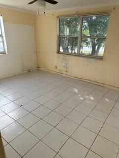 empty room featuring ceiling fan and light tile patterned floors