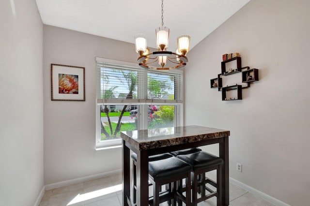 dining space with baseboards, a chandelier, and light tile patterned flooring