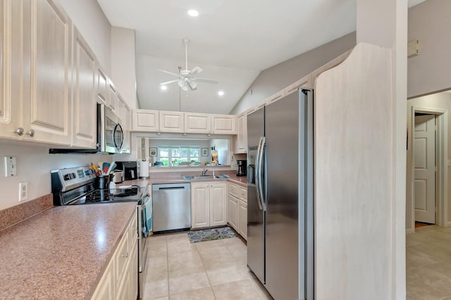 kitchen with light tile patterned floors, lofted ceiling, stainless steel appliances, a ceiling fan, and light countertops