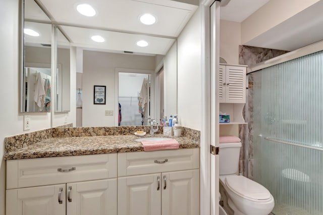 full bathroom featuring toilet, a stall shower, recessed lighting, and vanity