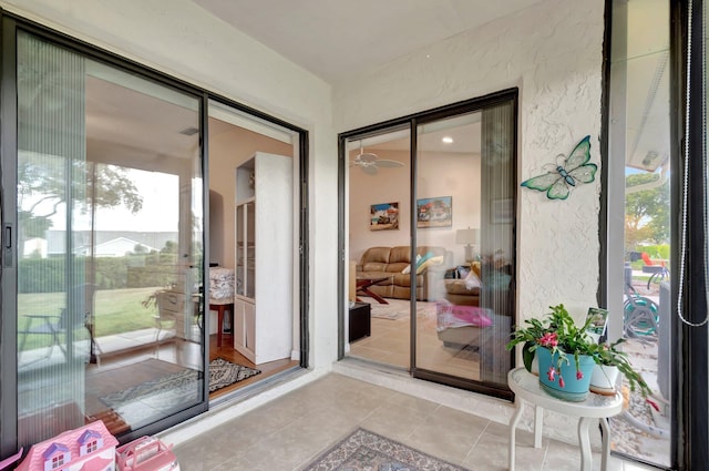 doorway with a sunroom, a textured wall, and tile patterned floors