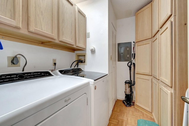 laundry room featuring separate washer and dryer, cabinet space, and electric panel