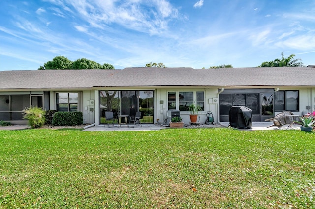 rear view of house with a patio, a yard, and a sunroom