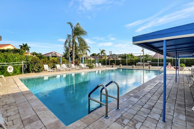 community pool featuring fence and a patio