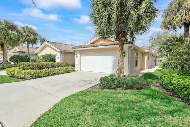 single story home with a garage, a tile roof, driveway, stucco siding, and a front yard